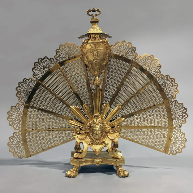 Una gran pantalla de fuego en forma de abanico de bronce dorado estilo Luis XVI con una máscara de Apolo finamente fundida.
